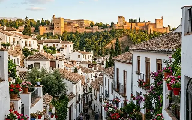 Una cuesta empedrada del Albaicín con la Alhambra arriba